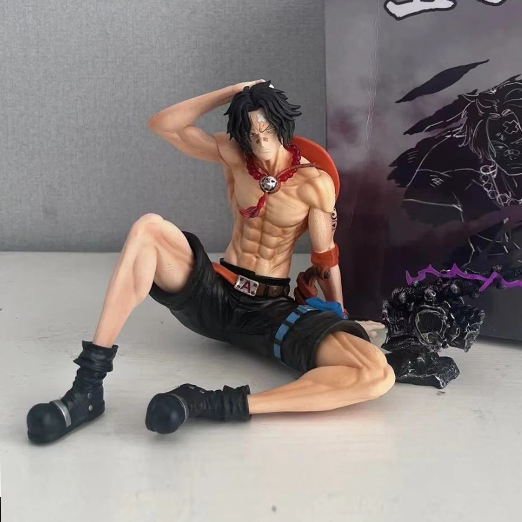 Figurine de Portgas D. Ace assis – One Piece – 12 cm avec chapeau, collier et tatouages.
